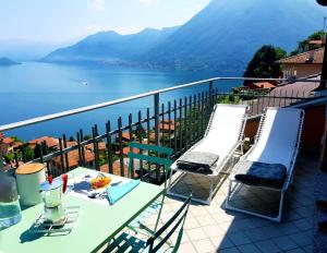 einen Tisch und Stühle auf einem Balkon mit Blick auf das Wasser in der Unterkunft La Rondinella - Loft with fantastic view on Lake Como in Argegno