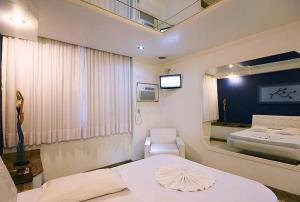 een ziekenhuiskamer met een bed en een spiegel bij Nosso Hotel (Adult Only) in Rio de Janeiro +40 foto's