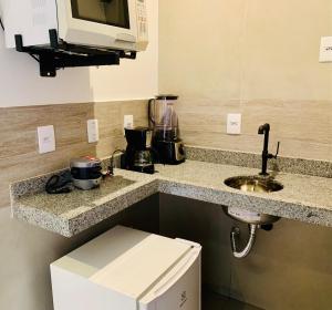 - un comptoir de cuisine avec évier et four micro-ondes dans l'établissement House Bike Sonora, à Conservatória