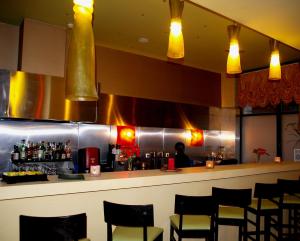 a bar in a restaurant with a person behind the counter at Delphi Art Hotel by Prima Hotels in Athens