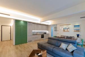ein Wohnzimmer mit einem blauen Sofa und einer Küche in der Unterkunft ALTIDO Apt for 6, with Terrace near Beach in Sestri Levante in Sestri Levante