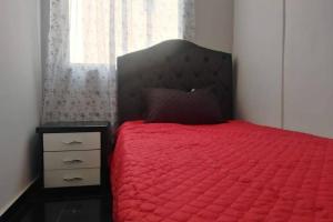 a bedroom with a red bed and a window at Apartamento acogedor con Piscina Excelente Sector in Ibagué +12 photos