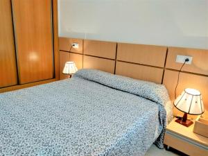 um quarto com uma cama e 2 candeeiros nas mesas em ACV - Costa Marfil II - 2 linea planta 5 norte em Oropesa del Mar