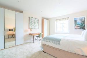 a white bedroom with a bed and a desk at 20 Montpellier - By Luxury Apartments in Cheltenham