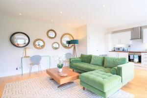 a living room with a green couch and a table at 20 Montpellier - By Luxury Apartments in Cheltenham