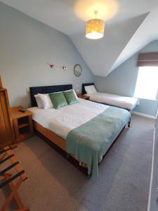 a bedroom with two beds and a table and a window at Rolling Wave Guesthouse in Bundoran