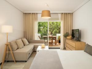 ein Wohnzimmer mit einem Sofa und einem Tisch in der Unterkunft Confortable estudio en medina garden ref 332 in Marbella