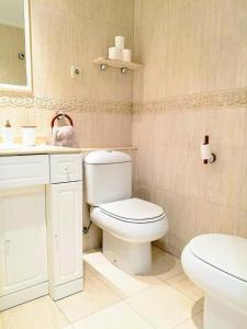 a bathroom with a white toilet and a sink at Apartamento Tibi - centro de Gandia in Gandía