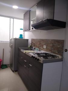une cuisine avec une cuisinière et un réfrigérateur dans l'établissement ALELI, NORTE cerca terminal, entr/sal aerpto, orquideorama,c de eventos valle del pcfco, base aérea mfs, à Cali