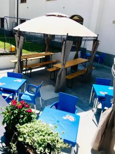 a group of tables and chairs with a large umbrella at Albergo Ristorante Dal Cogo in Spert