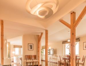 a dining room with a ceiling fan and wooden beams at Villa Modiva in Międzyzdroje