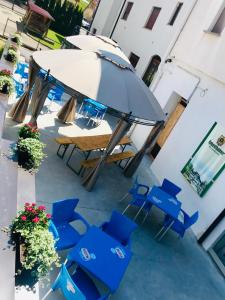 a group of blue chairs and an umbrella on a patio at Albergo Ristorante Dal Cogo in Spert +46 photos