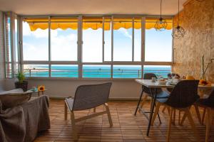 a living room with a table and chairs and a view of the ocean at Alicante Mediterraneo View in Alicante
