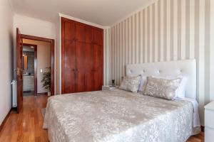 - une chambre avec un grand lit et une porte en bois dans l'établissement Refúgio de Sonho, à Ovar