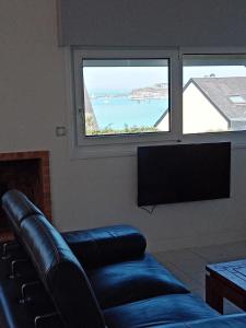 ein Wohnzimmer mit einem Sofa und einem großen Fenster in der Unterkunft Maison vue mer Granville in Granville