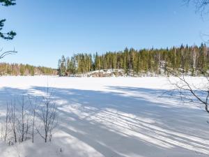 un gran campo cubierto de nieve con árboles en el fondo en Holiday Home Kaitaranta by Interhome, en Kyyrö