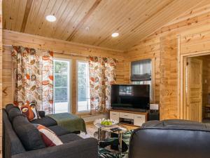 a living room with a couch and a television at Holiday Home Kaitaranta by Interhome in Kyyrö