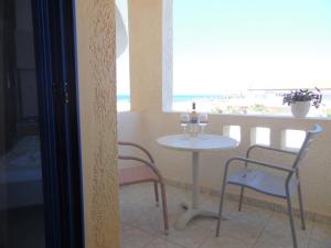 a table with two wine glasses and two chairs at Mike's Beach Apartments & Studios in Hersonissos
