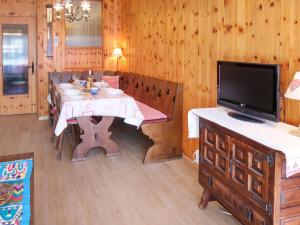 a dining room with a table and a flat screen tv at Apartment Bouleaux E 1 by Interhome in Nendaz