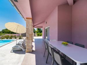 a patio with a table and chairs next to a pool at Holiday Home Mario by Interhome in Svetvinčenat