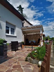 a patio with awning next to a house at Ferienwohnung Schultheiss in Plankenfels