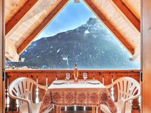 a table and chairs in a room with a view of a mountain at Apartment Tieja de Gotart-4 by Interhome in Vigo di Fassa