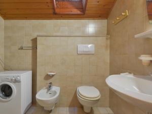 a bathroom with a toilet and a sink and a washing machine at Apartment Tieja de Gotart-4 by Interhome in Vigo di Fassa