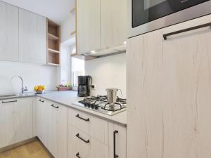 cocina con armarios blancos y fogones en Apartment Tieja de Gotart-3 by Interhome en Vigo di Fassa