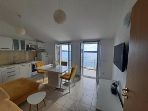 a kitchen and living room with a table and chairs at Ojdana Živković in Rogoznica