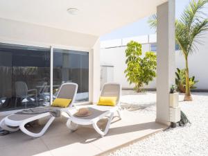 dos sillas y una mesa frente a una casa en Villa Blanca Playa Paraíso by Interhome, en Playa Paraiso