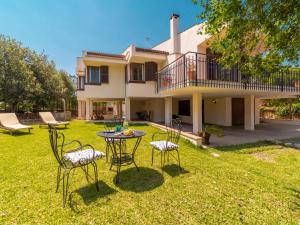 einen Garten mit Stühlen und einem Tisch vor einem Haus in der Unterkunft Villa Can Jeroni by Interhome in Alcúdia