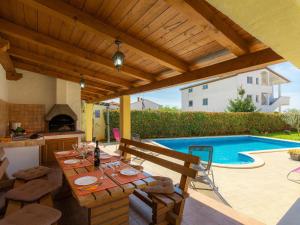 patio ze stołem, kuchnią i basenem w obiekcie Holiday Home Villa Zara by Interhome w Puli
