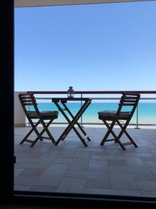een tafel en 2 stoelen op een balkon met uitzicht op de oceaan bij SunRise Apartments in Termoli