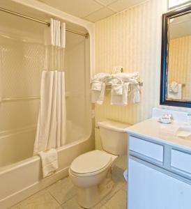 Bay View Resort Myrtle Beach في ميرتل بيتش: حمام مع مرحاض وحوض استحمام ومغسلة
