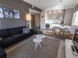 a living room with a couch and a table and a kitchen at Holiday Home Tunturinlaita c9- 2 skipasses included by Interhome in Sirkka