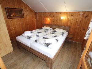 a bed in a room with wooden walls and wood floors at Holiday Home Kyjov u Krásné Lípy by Interhome in Kyjov