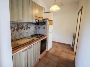 a kitchen with stainless steel cabinets and a tile floor at Apartment Residenza Agrifoglio-16 by Interhome in Luino +27 photos