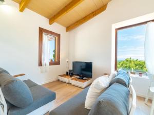 a living room with a couch and a tv at Holiday Home Sa Caseta des Camp by Interhome in Banyalbufar