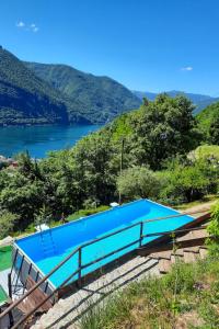 a blue swimming pool with a lake in the background at Holiday Home Casa Pina by Interhome in Porlezza