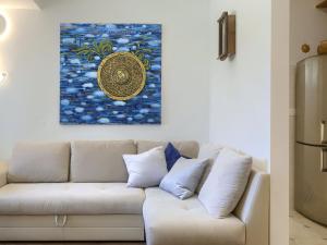 a white couch in a living room with a painting on the wall at Holiday Home Punta 2 by Interhome in Umag