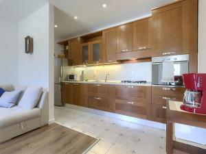 a kitchen with wooden cabinets and a couch in it at Holiday Home Punta 2 by Interhome in Umag +28 photos