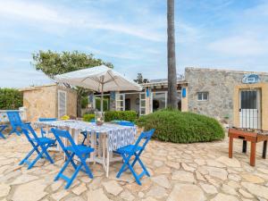 a patio with a table and chairs and an umbrella at Villa Can Delfin by Interhome in Alcudia