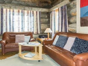 una sala de estar con 2 sofás de cuero y una mesa. en Holiday Home Luostonseita 1 by Interhome en Luosto