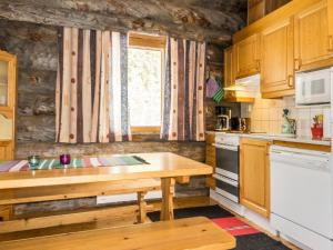 a kitchen with a wooden table and a window at Holiday Home Luostonseita 1 by Interhome in Luosto