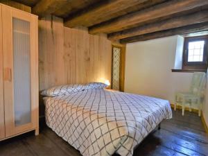 a bedroom with a bed in a room with wooden ceilings at Chalet Rustico Rebustella by Interhome in Civo