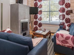 sala de estar con 2 sofás azules y chimenea en Holiday Home Villa hanki by Interhome, en Ruka