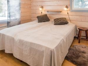 a bedroom with a white bed with two pillows on it at Holiday Home Villa hanki by Interhome in Ruka