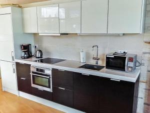 een keuken met een spoelbak en een magnetron bij Holiday Home Villa marina by Interhome in Padasjoki