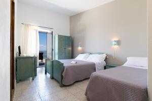 a hotel room with two beds and a balcony at S'Enis Monte Maccione in Oliena