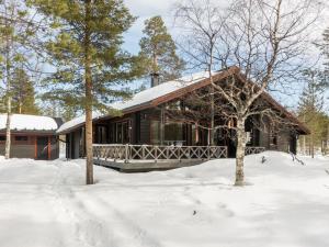 a log cabin in the snow with trees at Holiday Home Villa aihki by Interhome in Luosto